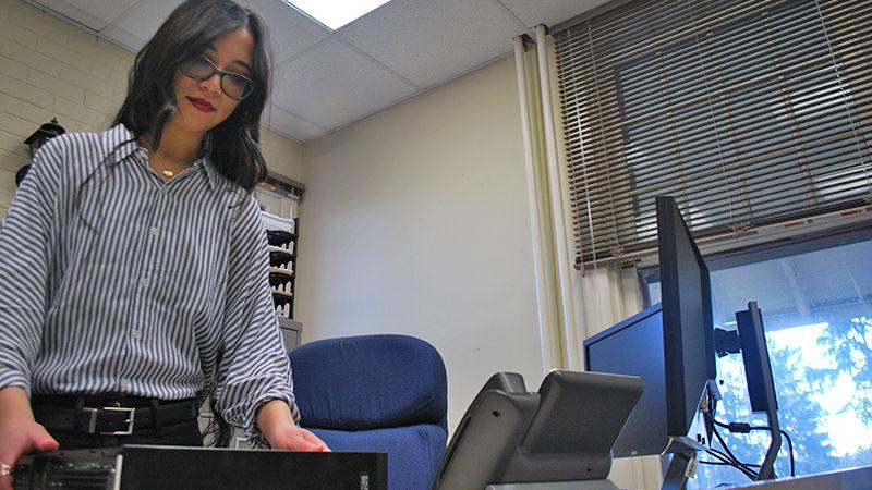 IST Emily Lautenbach fixes a computer